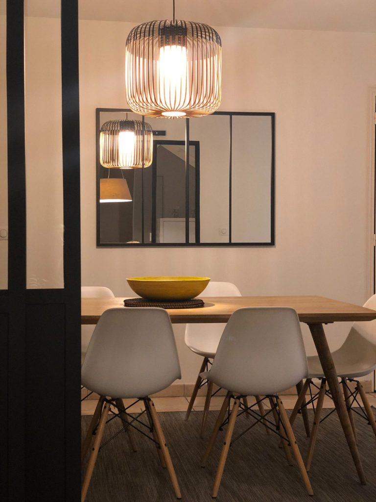 Salle à manger moderne avec une grande table et des chaises grises, éclairage suspendu. décoration d'intérieur à Saint Malo